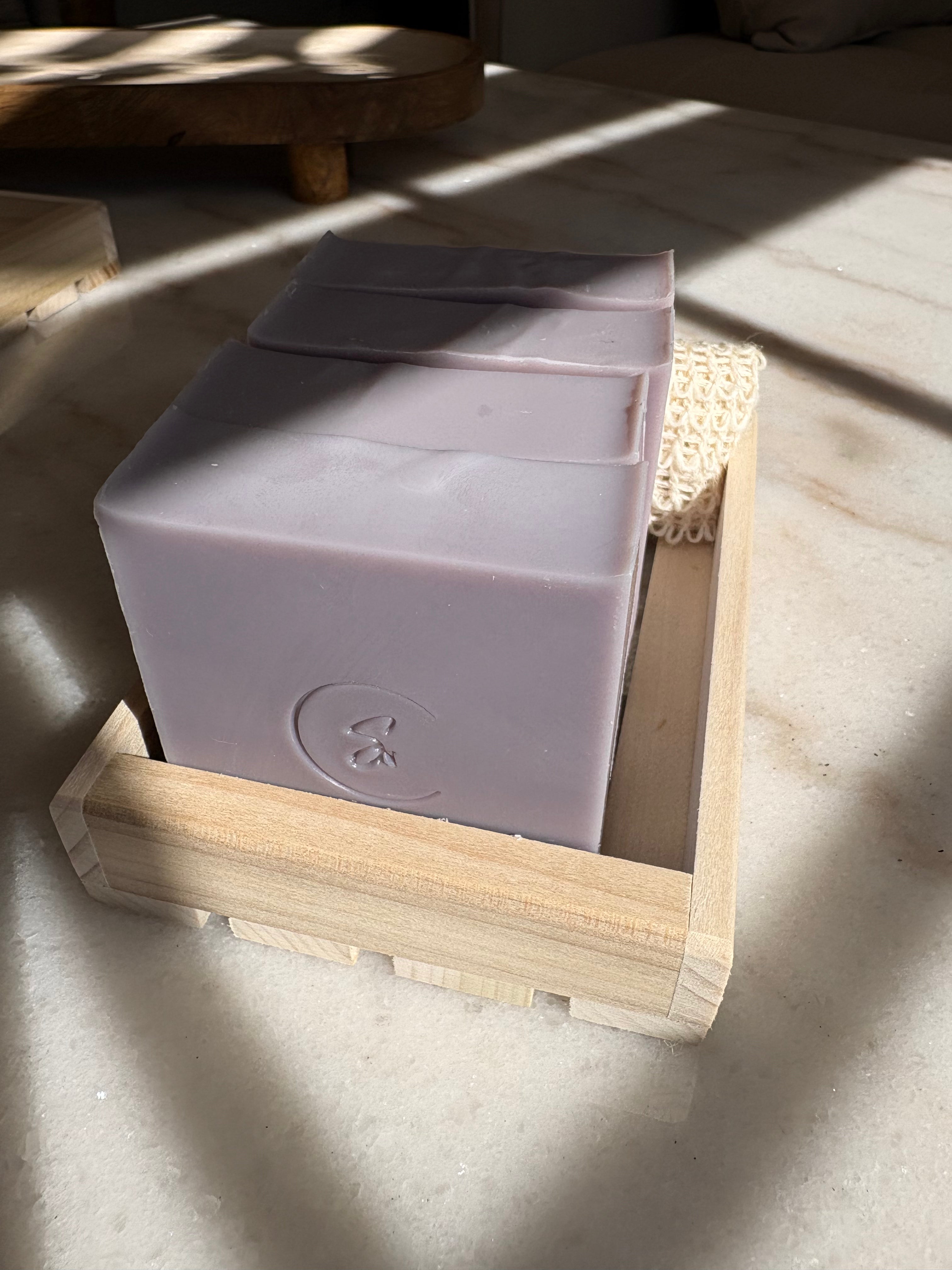 Artisan Gromwell beauty bar in a wooden holder on a light surface