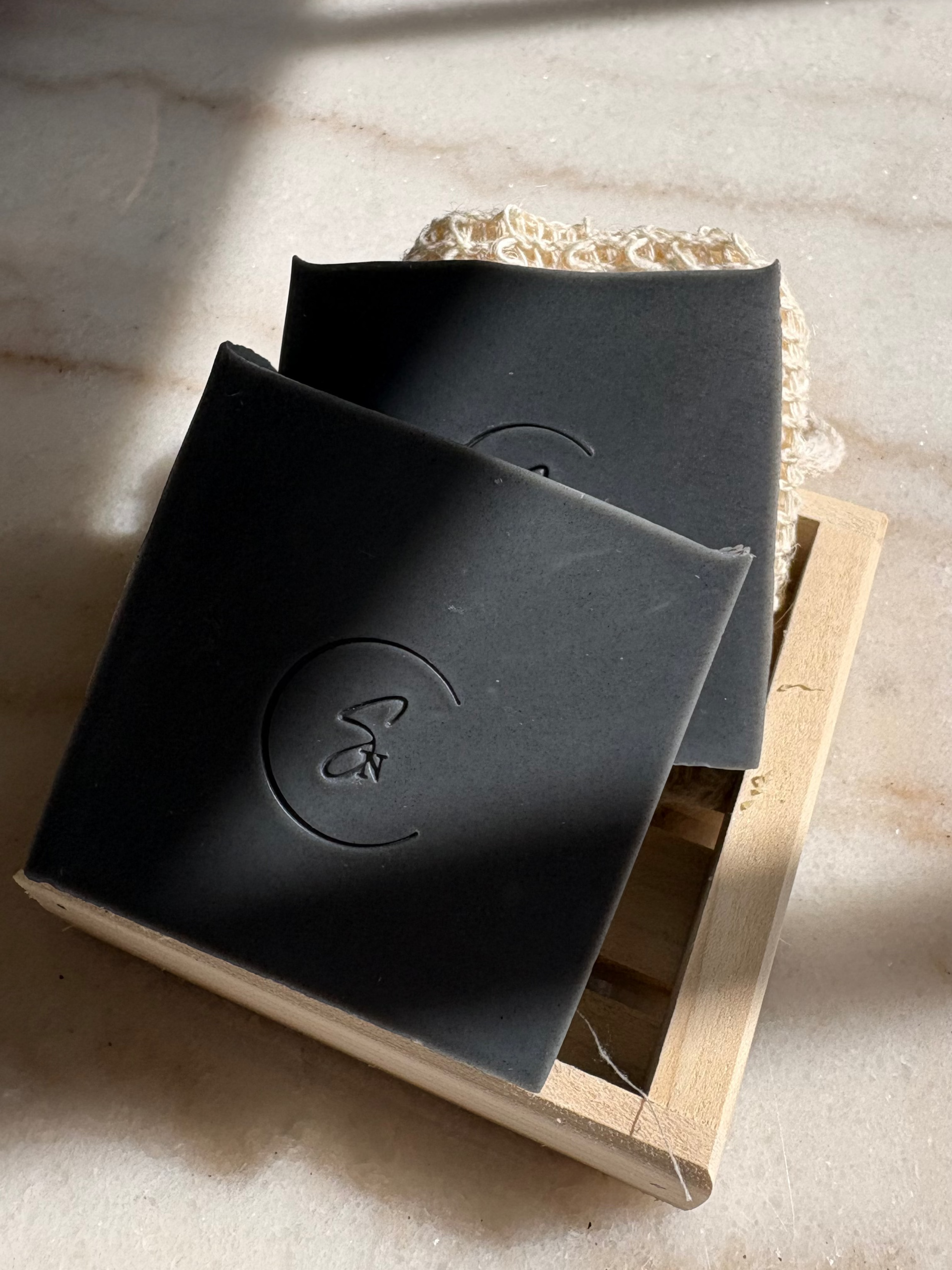 Deep cleansing charcoal soap styled in minimalist setting
