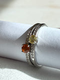 Two silver rings with gemstones on a white surface