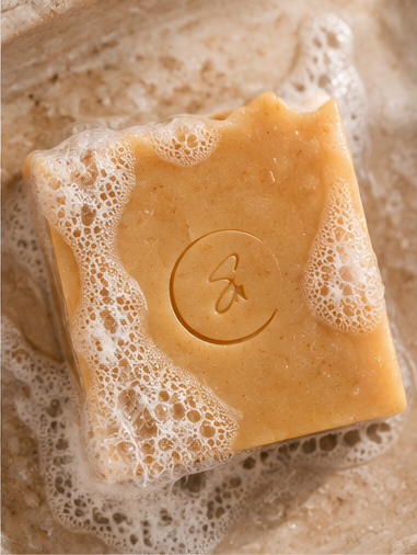 Golden Ginger handmade soap with water droplets and soft creamy lather, highlighting its smooth surface.