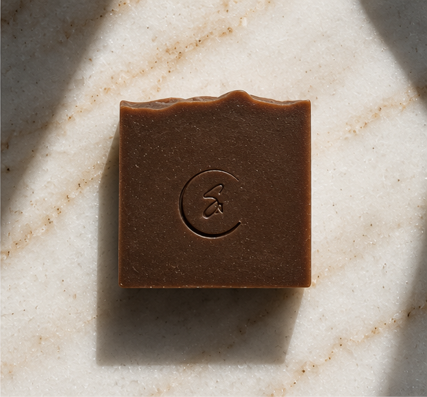 Overhead view of Spiced Orange and Coffee artisan soap displayed against a warm neutral background.