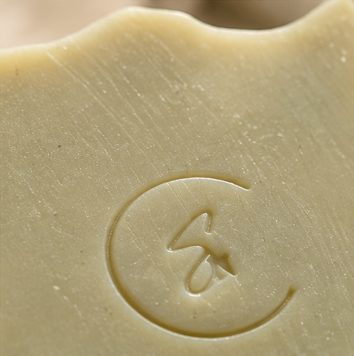 Close-up of Woodland soap highlighting its smooth finish and subtle moss-green clay color.