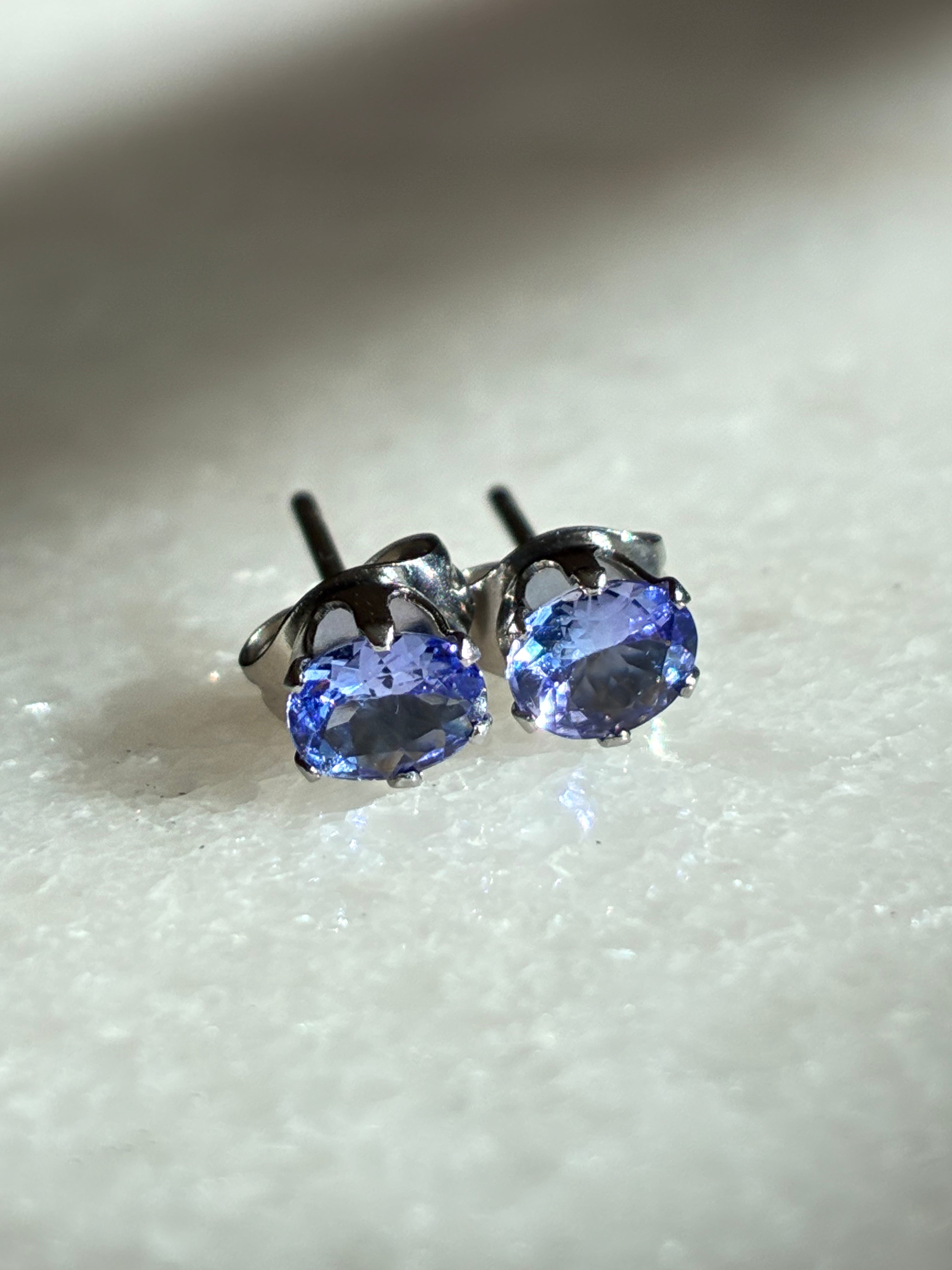Pair of blue gemstone stud earrings on a light background